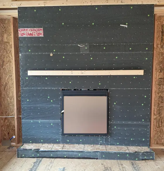 Fireplace unit set into a framed wall with the hearth built out below it
